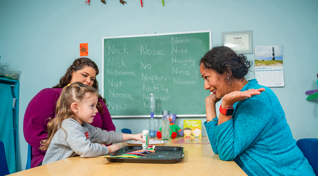 Two members of UNCG's CYFCP working with a young child